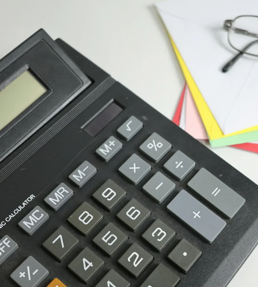 Calculadora sobre papéis coloridos representando a apuração de novos tributos